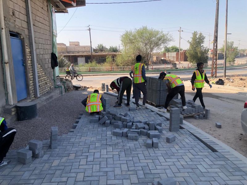 Al Shamsh crew installing the interlocking concrete-block sidewalk.