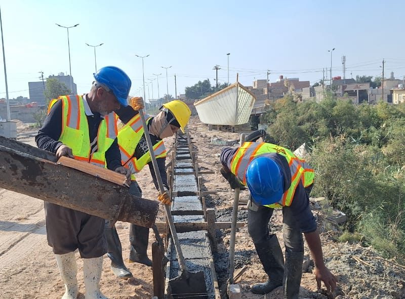 Pouring continuous concrete curb and gutter with formwork.