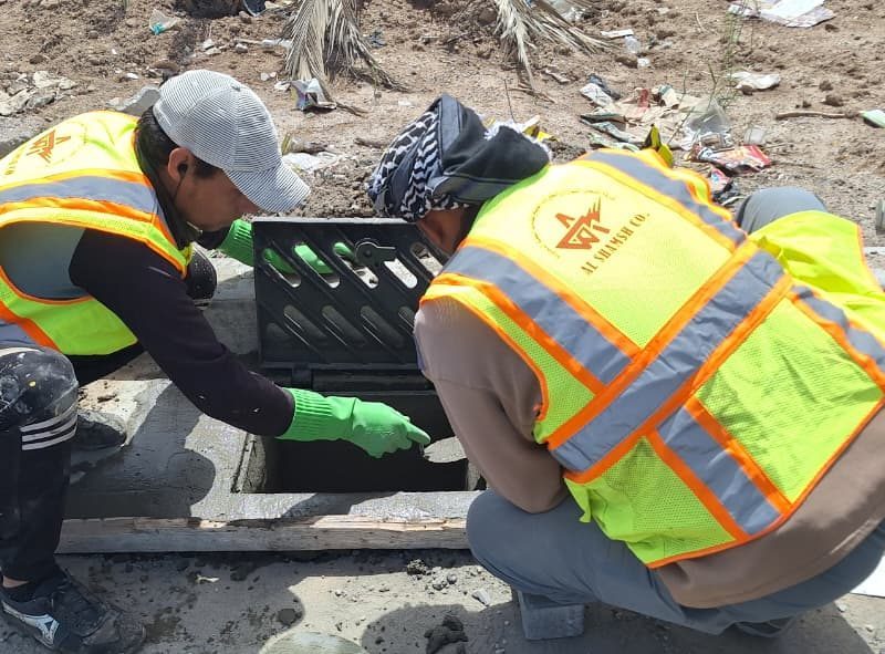 Installing a heavy-duty rain-water drainage grate at the curb line.