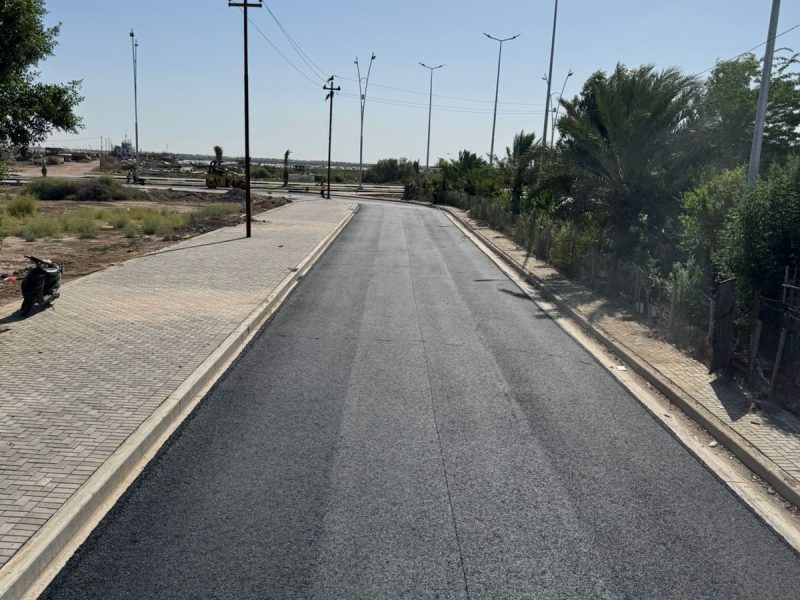 Completed road section with adjacent interlock sidewalk.