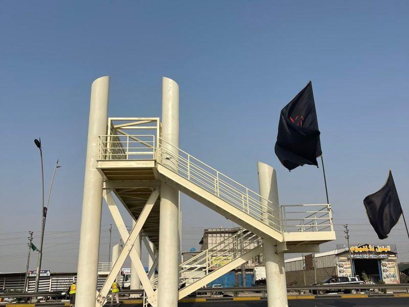 Completed staircase-and-landing structure in cream finish — the pedestrian access point to the bridge.