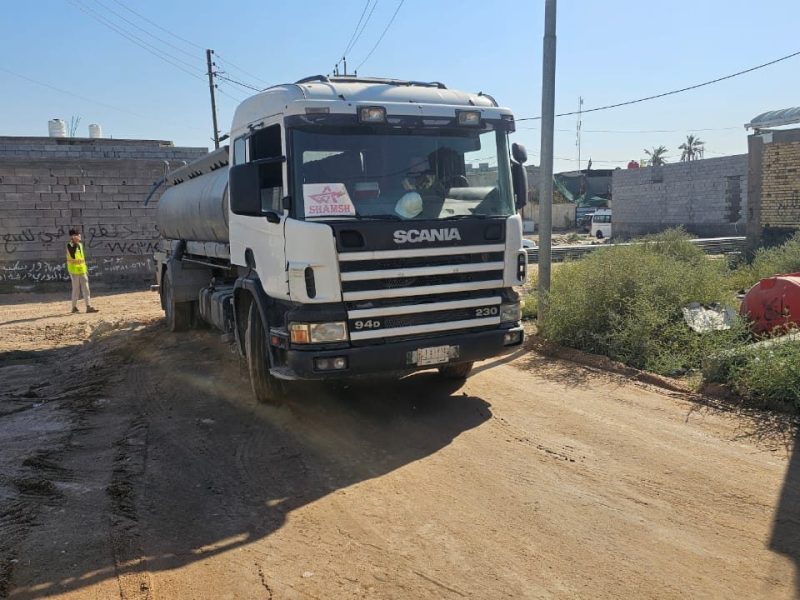 Scania water tanker providing dust suppression and moisture conditioning ahead of compaction.