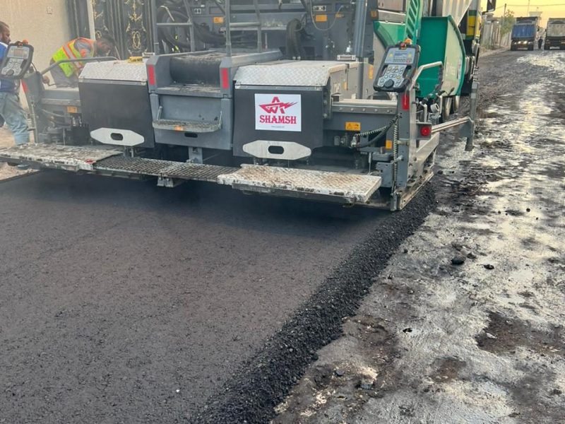 Freshly laid asphalt mat behind the Vögele paver screed.
